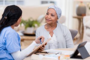 Serious female cancer patient listens to home healthcare nurse